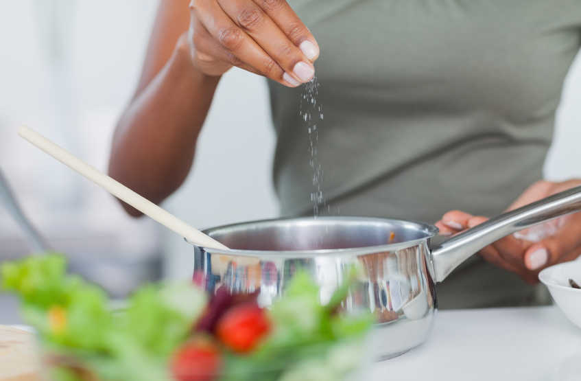 Woman seasoning her pot at home in kitchen